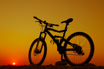 Fototapeta na wymiar Silhouette of mountain bicycle against sunset sky