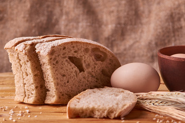 fresh delicious bread, concept for baking. Eggs in clay bowl and wheat sprouts on wooden table. concept home teste
