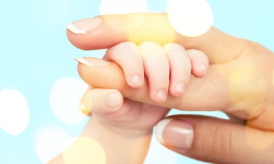 Close up photo of father holding baby hand