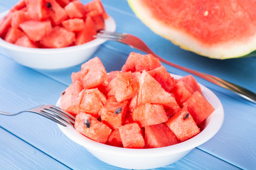 fresh watermelon cut into cubes on plates.