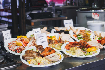 Delicious plates with a variety of grilled fish and seafood with mashed potatoes served with salad...