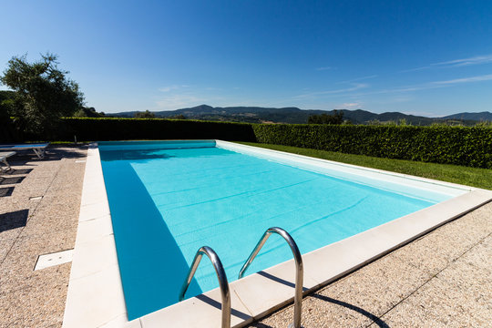 Leerer Swimmingpool vor blauem Himmel in der Toscana