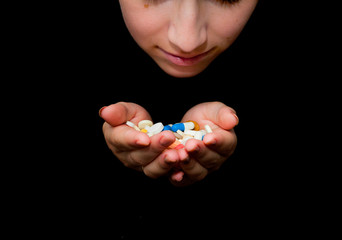 Woman's holding cupped hands full of pills