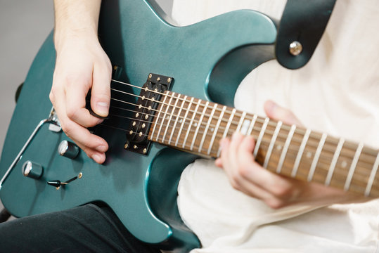 Close up of man playing on electric guitar