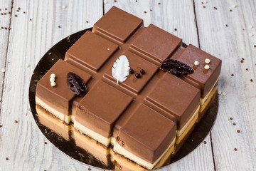 Dark chocolate vegan cake with candies on wooden background