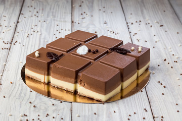 Dark chocolate vegan cake with candies on wooden background