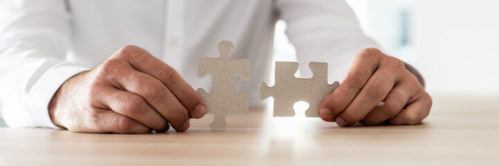 Businessman holding matching puzzle pieces