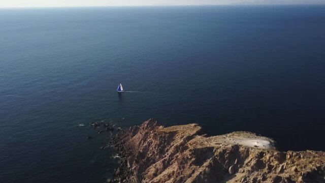 Sailboat passes by Akrotiri Lighthouse, aerial