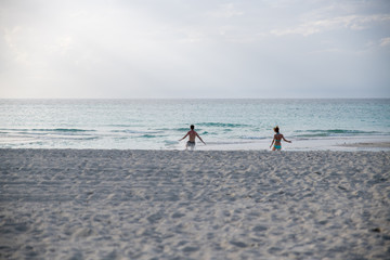 unknown young couple running to the sea