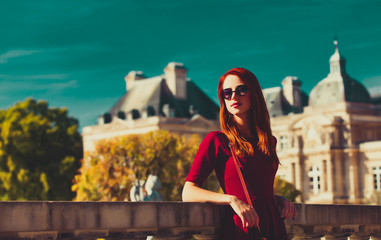 style redhead girl in glasses near Luxembourg Palace in Paris