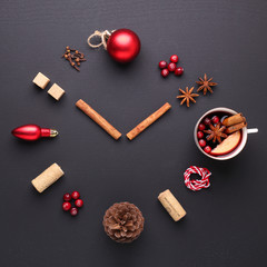 A clock in the form of spice for mulled wine. Cinnamon, anise stars, cranberries, brown sugar. Concept, creative work.