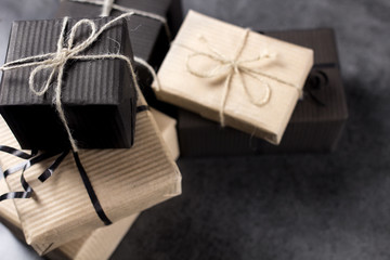 Black and brown gift boxes for holidays gift on dark texture background.