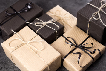Hand made black and brown gift boxes on dark texture surface.
