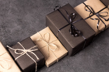 Hand made black and brown gift boxes on dark texture surface.