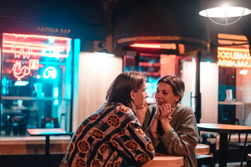 Young couple at the bar, street of the night city