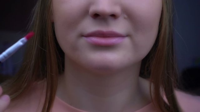 Young beautiful girl is caring for the face skin, close up view super slow motion