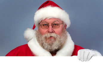 Naklejka premium Santa Claus holding white board. Christmas celebration concept. Copyspace