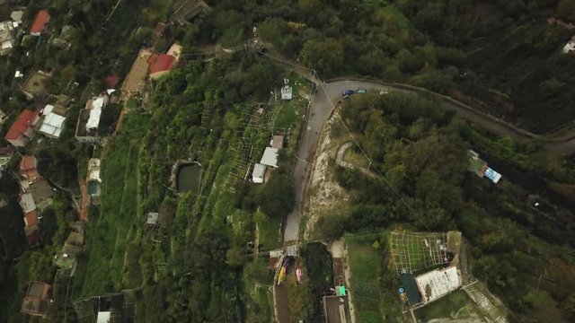 Overhead aerial, mountain road in lush Italian landscape