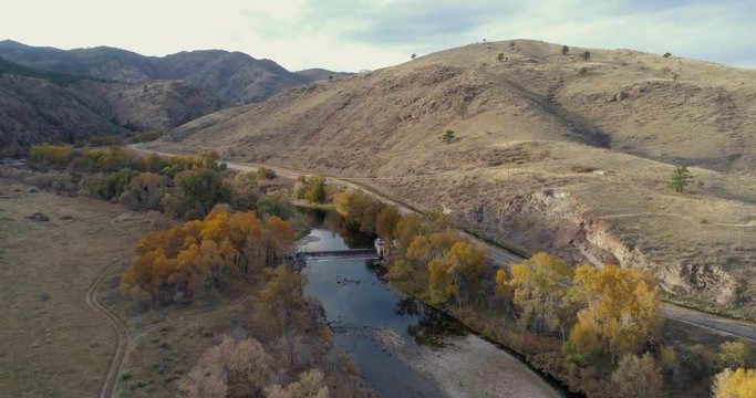 Cache la Poudre River with a water diversion dam at Rocky Mountain foothills in northern Colorado above Fort Collins, fall scenery