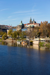 Colorful autumn Prague gothic Castle with the Lesser Town above River Vltava in the sunny Day,...