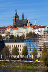 Colorful autumn Prague gothic Castle with the Lesser Town above River Vltava in the sunny Day,...