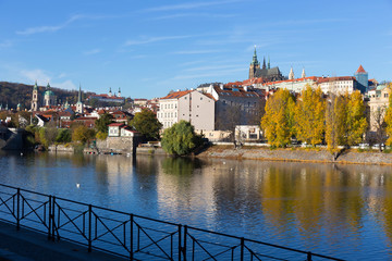 Colorful autumn Prague gothic Castle with the Lesser Town above River Vltava in the sunny Day, Czech Republic