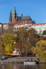 Colorful autumn Prague gothic Castle with the Lesser Town above River Vltava in the sunny Day,...
