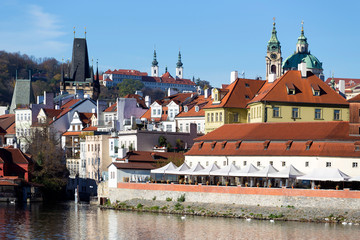 Obraz premium Colorful autumn Prague St. Nicholas' Cathedral with the Lesser Town above River Vltava in the sunny Day, Czech Republic