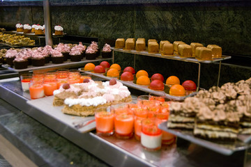 Selection of desserts at a dessert and cake buffet, served on stainless steel tables