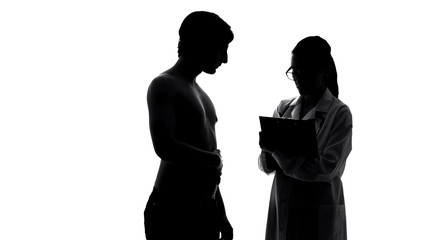 Silhouette of man at medical examination, female doctor writing prescription
