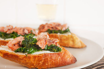 Smoked salmon and spinach canape served on white plate