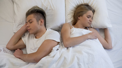 Obraz na płótnie Canvas Young couple sleeping peacefully on comfortable orthopedic mattress, relax dream