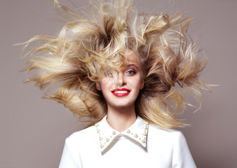 beauty portrait of attractive young caucasian woman blond on beije background studio shot hair wind...