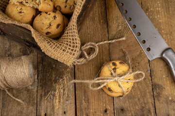 Cookies tied with a gray jute string into a bow. Cookies of sweets on a wooden kitchen table.