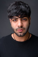 Obraz premium Young handsome Indian man against gray background