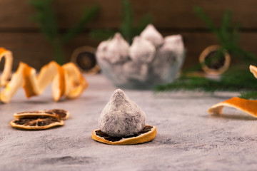 Chocolate candy on a slice of dry lemon, on the background-Christmas decorations.