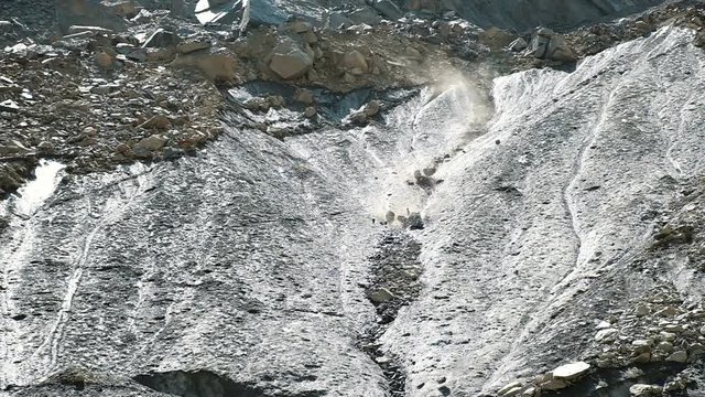 Rockfall in the mountains, stones fall down from the glacier, slow motion