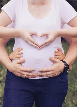 Closeup pictures of pregnant woman's belly with hands