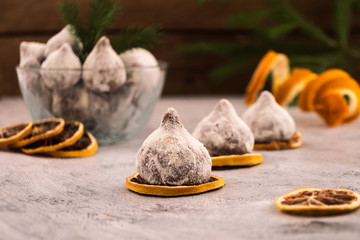 A beautiful dessert for the holiday - chocolate truffles in powdered sugar, slices of dry lemon.