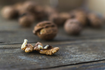 Whole and chopped walnuts on wooden table