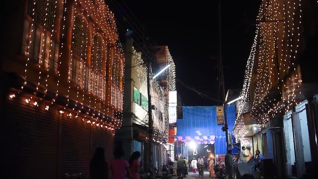 Indian streets decoration with colorful lights for Christmas and Diwali, people walking, slow motion