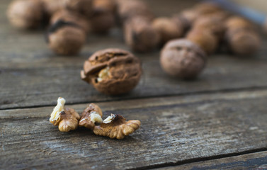 Whole and chopped walnuts on wooden table