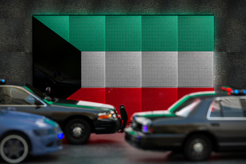 Bright digital display Kuwait flag in city as cars drive past