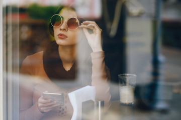 brunette girl using phone while at a restaurant
