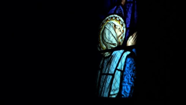 Panning shot of virgin Mary vitrage in old church.