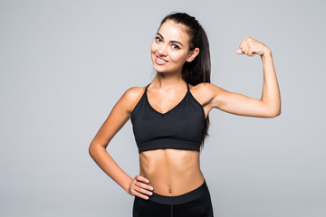 Fototapeta na wymiar Cheerfully smiling fitness sporty woman demonstrating biceps isolated on white background