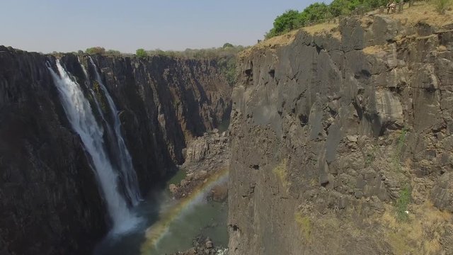 Drone shot of a Waterfall and a Rainbow inside the canyon at Victoria Falls in dry season