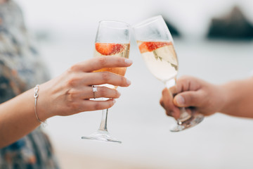 Couple with champagne glasses on the beach. 