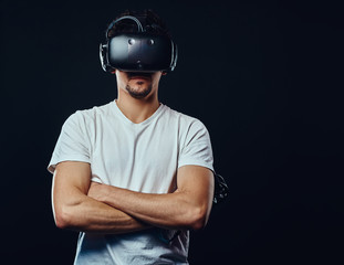 Man with bristle dressed in white shirt playing games with virtual reality goggles.