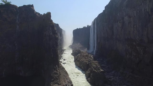 Drone view from inside the canyon at Victoria Falls, revealing the river and waterfalls in Dry Season